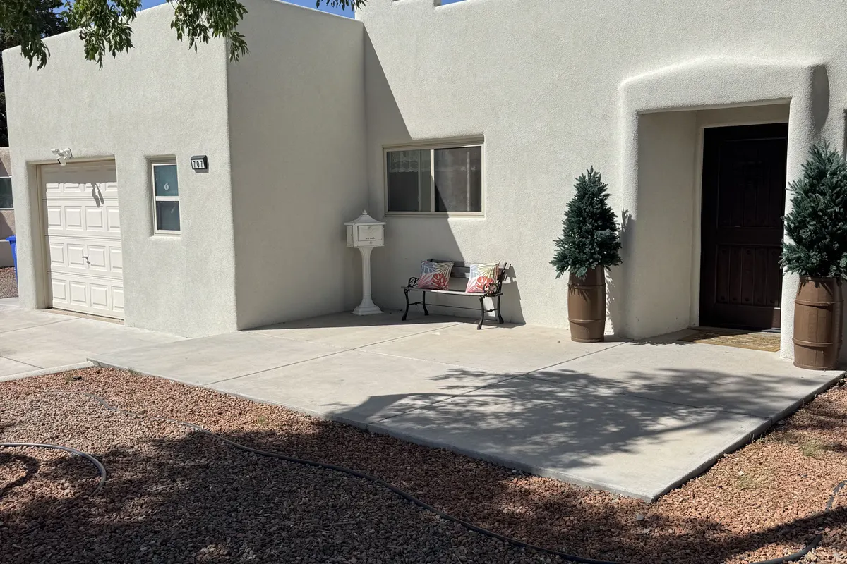 Courtyard entry of a stucco home with a dark entry door