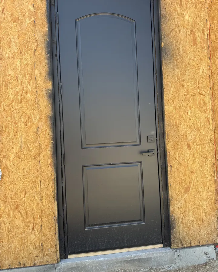 New dark exterior door in a sheathed opening
