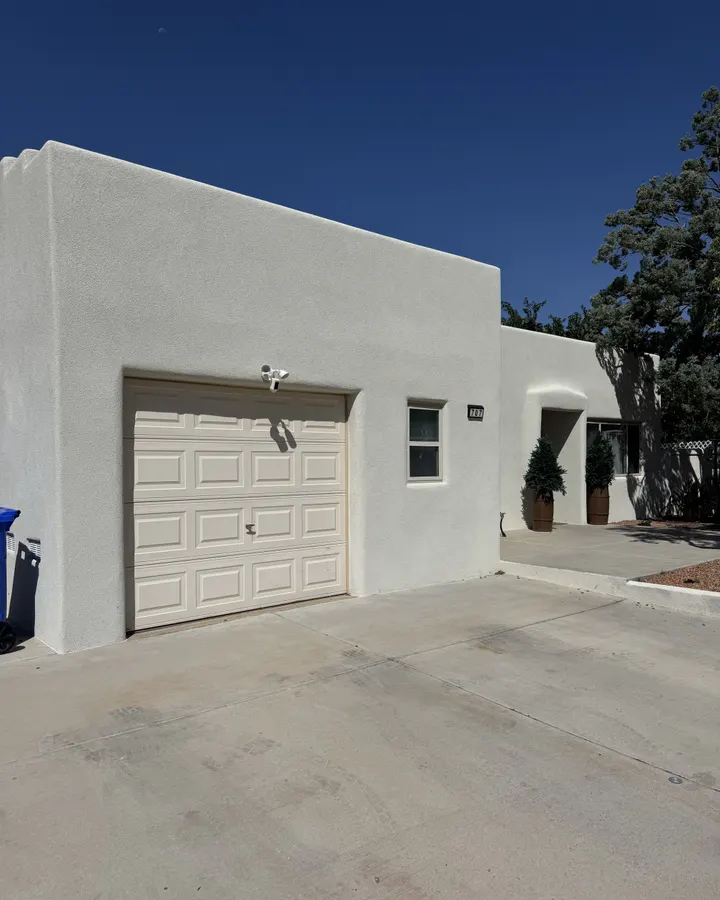 Driveway and attached garage of a stucco home