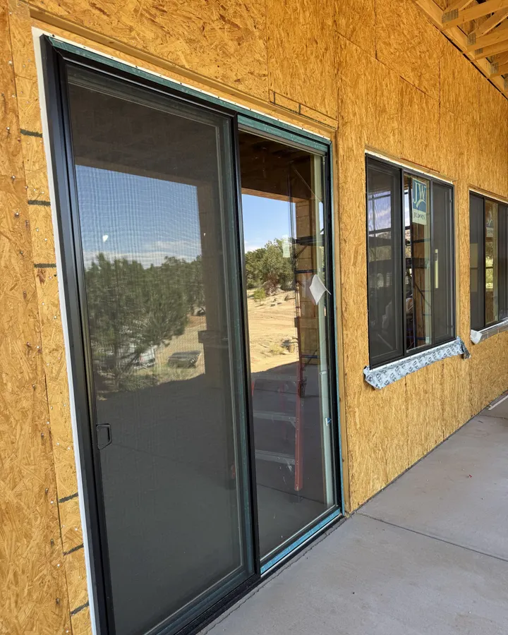 New sliding patio door installed along a sheathed wall