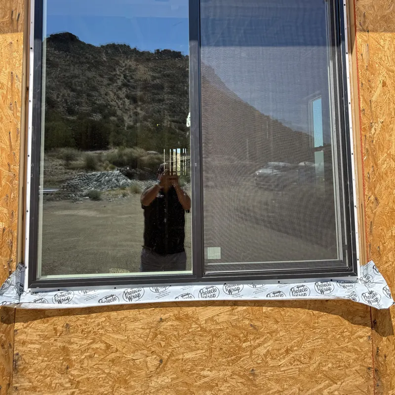 New slider window set into a sheathed opening with flashing tape at the sill