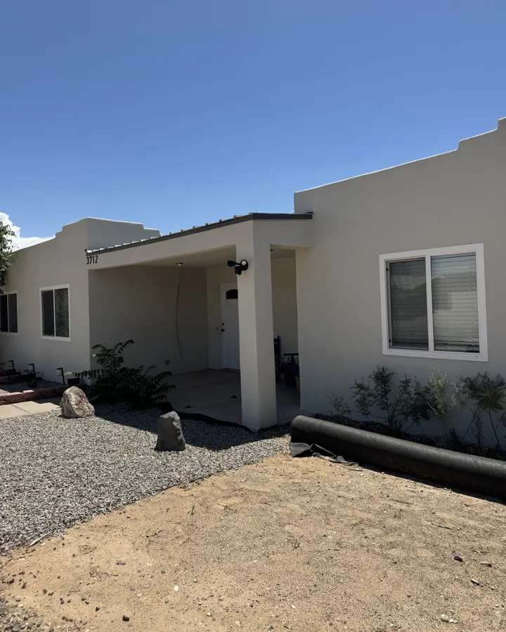 Side of a stucco home with new windows