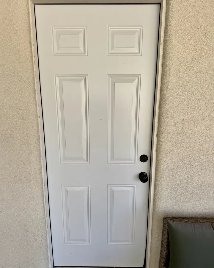 White panel exterior door in a stucco opening