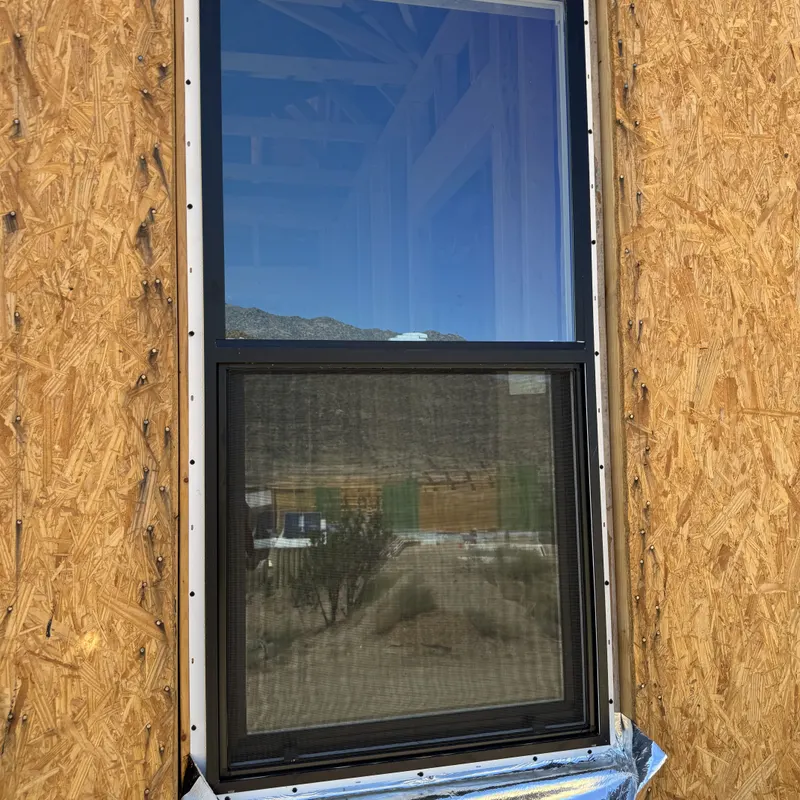 New window set into a sheathed opening with flashing tape at the sill