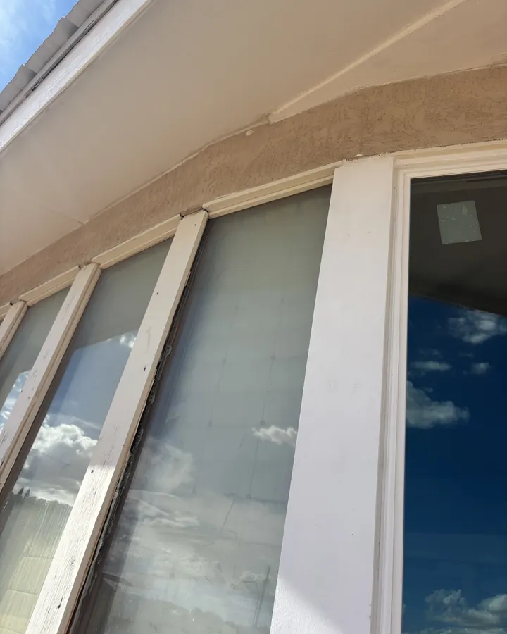White windows in a stucco wall seen from below